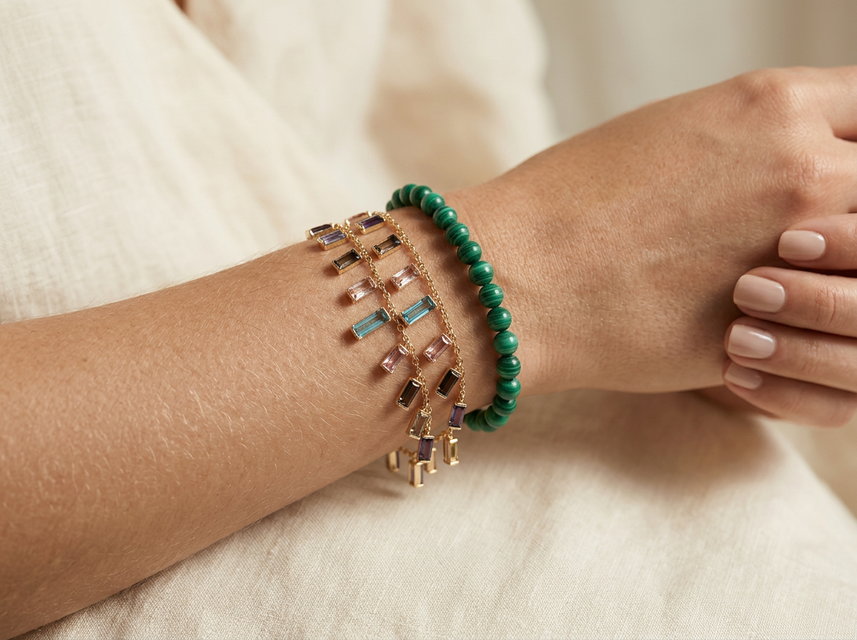 Wrist stacked with a gemstone charm chain and a malachite bead strand